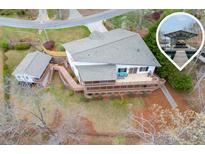 Stunning lakefront home featuring a large deck, boat dock, and a charming guest house, all set amidst a serene natural landscape at 5995 Lanier Heights Cir, Buford, GA 30518