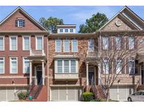 Charming brick townhome featuring a covered front porch and attached garage at 1942 Ridgemont Ln, Decatur, GA 30033