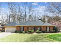 Charming brick home featuring a well-manicured lawn and attached two-car garage, perfect for suburban living at 5270 Forest Brook Pkwy, Marietta, GA 30068