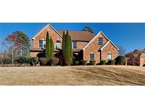 Beautiful two-story brick home with mature landscaping and a well-manicured lawn at 2413 Brynlynn Woods, Conyers, GA 30013
