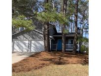 Charming exterior view of a home featuring a two-car garage and a cozy front porch at 3201 Palomino Dr, Powder Springs, GA 30127
