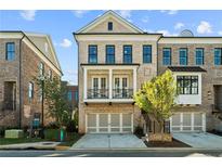 Charming three-story townhome with brick facade, balcony, and attached two-car garage at 235 Briscoe Way # 7, Alpharetta, GA 30009