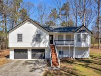 Charming home featuring a two-car garage, front porch, and classic white siding with black trim at 353 Chateauguay Dr, Ellenwood, GA 30294