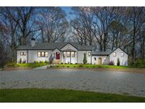 Charming white-painted brick home with a manicured lawn and a gravel driveway at 4900 College St, Union City, GA 30291