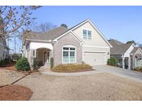 Charming home featuring brick accents, a well-manicured lawn, and an attached garage at 1011 Stillington Way, Kennesaw, GA 30152
