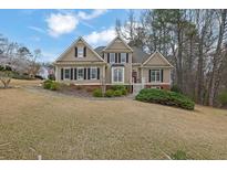 Charming two-story home with neutral siding, black shutters, manicured landscaping, and a welcoming red front door at 300 Gold Rdg, Canton, GA 30114