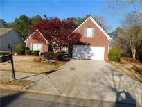 Charming brick home featuring a well-manicured lawn and a two-car garage, blending comfort with curb appeal at 873 Port West Dr, Auburn, GA 30011