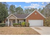 Charming one-story home featuring a combination of brick and siding, lush landscaping, and an attached two-car garage at 2279 Perch Sw Way, Marietta, GA 30008