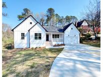 Charming new construction with a white exterior, attached two-car garage, and a well-manicured lawn at 2295 Rocky Mountain Ne Rd, Marietta, GA 30066