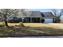 Charming one-story home with blooming tree, well-maintained lawn, and attached two-car garage at 75 Doves Nest, Covington, GA 30016