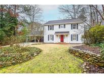 Charming two-story home featuring a red door, black shutters, and a well-manicured front yard at 970 Winding Creek Trl, Atlanta, GA 30328