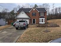 Charming brick two-story home featuring a well-maintained lawn, and a welcoming entrance at 3963 Sautee Trl, Conley, GA 30288