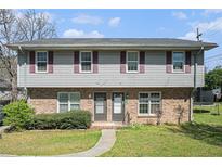 Traditional two-story duplex featuring brick facade and neutral siding at 1143 Forest Villa Nw Dr, Conyers, GA 30012