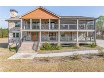 Inviting two-story home with a brick facade, a double porch, and a charming covered porch at 5182 Braselton Hwy, Auburn, GA 30011