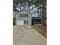 Charming two-story home with green siding, black shutters, and a convenient one-car garage at 2179 Summertown Dr, Norcross, GA 30071