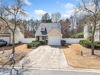 Charming home featuring a well-manicured lawn, mature trees, and a convenient one-car garage at 245 Osmanthus Way, Canton, GA 30114