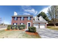 Charming brick home featuring a two-car garage and well-maintained front yard at 921 Dunagan Way, Lawrenceville, GA 30045