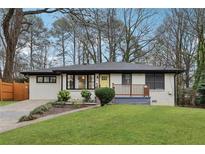 Charming one-story home with a beautifully landscaped front yard and inviting yellow front door at 1090 Indale Sw Pl, Atlanta, GA 30310