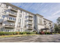 Elegant condominium building featuring multiple balconies, a well-manicured lawn, and a covered entrance at 3201 Lenox Ne Rd # 16, Atlanta, GA 30324