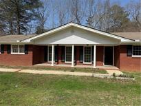 Charming brick ranch-style home with black shutters and a welcoming covered front porch at 3153 Lake Monroe Rd, Douglasville, GA 30135
