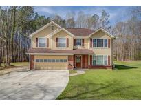 Charming two-story home with a well-manicured lawn, attached garage, and traditional architectural details at 440 Cottonpatch Rd, Lawrenceville, GA 30046
