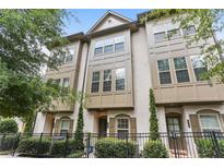 Charming three-story townhome with tan brick, neutral trim, and a wrought iron fence at 605 Broadview Ne Pl, Atlanta, GA 30324