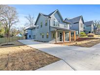 Modern two-story home with a covered front porch and a long driveway on a sunny day at 1247 Bridges Sw Ave # B, Atlanta, GA 30310