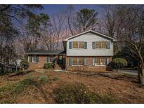 Charming two-story home featuring a brick facade, blue shutters, and a well-maintained front yard at 1677 Foresta Ct, Atlanta, GA 30341