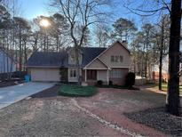 Well-maintained home with an attached garage and beautifully landscaped front yard at 4811 West Lake Se Dr, Conyers, GA 30094