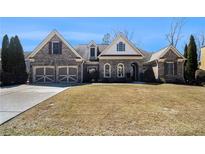 Charming brick home with a manicured lawn, two-car garage, and arched entryway, perfect for Gathering living at 448 Hanover Drive, Villa Rica, GA 30180