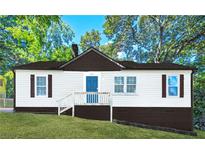 Charming one-story home with a blue door, dark shutters, and landscaped front yard at , Atlanta, GA 30315