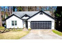 Charming single-story home featuring black trim, a gray roof, and a two-car garage at 3065 Wildflower Ln, Snellville, GA 30039
