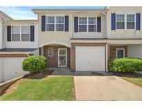 Charming townhome featuring a one-car garage, brick accents, and a well-maintained lawn at 695 Georgetown Ct, Jonesboro, GA 30236