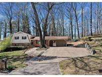 Charming exterior showcasing a well-maintained home with a spacious driveway and a convenient covered parking area at 3334 Spring Meadow Ct, Tucker, GA 30084