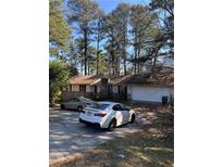 Charming single-story home with a two-car garage and driveway, surrounded by mature trees at 3939 Boring Rd, Decatur, GA 30034