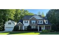 Charming two-story home featuring stone accents, black shutters and a well-manicured lawn at 310 Persimmon Dr, Sharpsburg, GA 30277