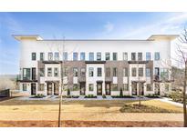 Contemporary townhome featuring a mix of brick and siding with black trimmed windows and small front yards at 7220 Summit Pl, Alpharetta, GA 30009