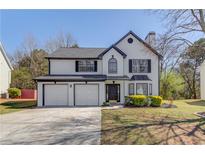 Charming two-story home featuring a two-car garage and meticulously landscaped front yard at 667 Oaktree Park Ct, Lawrenceville, GA 30044