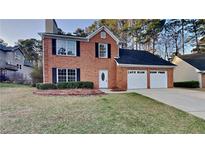Charming two-story brick home featuring a well-manicured lawn and a two-car garage at 1809 Fairpointe Trce, Stone Mountain, GA 30088
