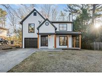 Charming two-story home with a front porch, garage, and manicured lawn at 6382 Revena Dr, Morrow, GA 30260