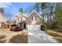 Charming two-story brick home features a well-manicured lawn and an attached two-car garage at 830 Nottingham Se Dr, Smyrna, GA 30082