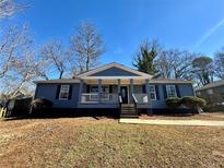 Charming single-story home with a welcoming front porch and well-maintained landscaping at 383 Third Ave, Scottdale, GA 30079