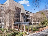 Inviting condo exterior with covered entrance, stone accents, mature trees, and well-maintained landscaping at 1110 Highland Bluff Drive Se # 110, Atlanta, GA 30339