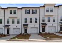 Newly built townhomes feature a white exterior, multiple windows, and a one car garage at 3135 Washburn St, Atlanta, GA 30354