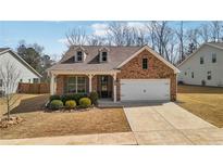 Charming single-story brick home featuring a manicured lawn and a two-car garage at 158 Rolling Hills Pl, Canton, GA 30114