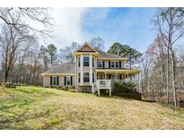 Charming two-story home featuring a welcoming front porch and well-maintained landscaping nestled in a serene wooded setting at 120 Mill Creek Ct, Acworth, GA 30101