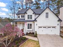 Charming two-story home with a two-car garage and a lovely magnolia tree in the front yard at 303 Valley Green Ct, Woodstock, GA 30189