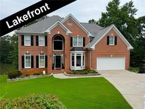 Stunning two-story brick home with a well-manicured lawn and attached two car garage at 335 Lake Bluff Ct, Suwanee, GA 30024