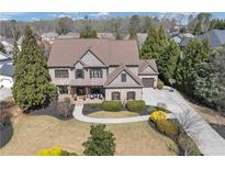 Stately two-story brick home showcasing manicured lawn, mature trees, and long driveway at 4020 Toulon Ln, Cumming, GA 30040