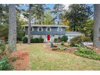 Charming two-story home with stone accents, well-manicured lawn, and mature trees surrounding at 4400 Huntington Cir, Dunwoody, GA 30338
